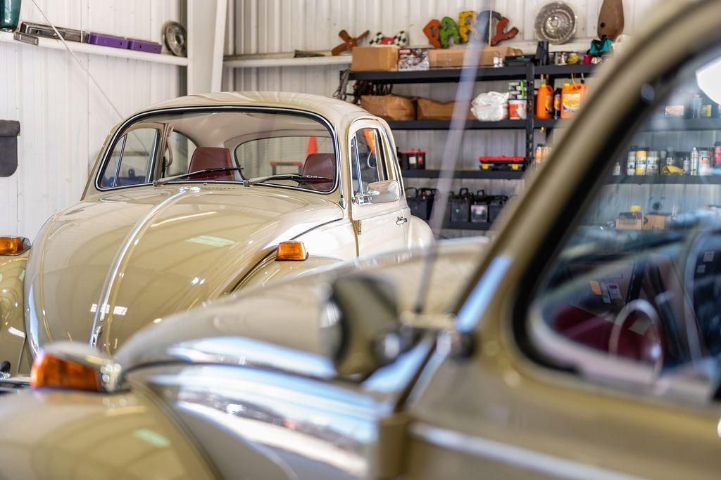 A couple of cars are parked in a garage.