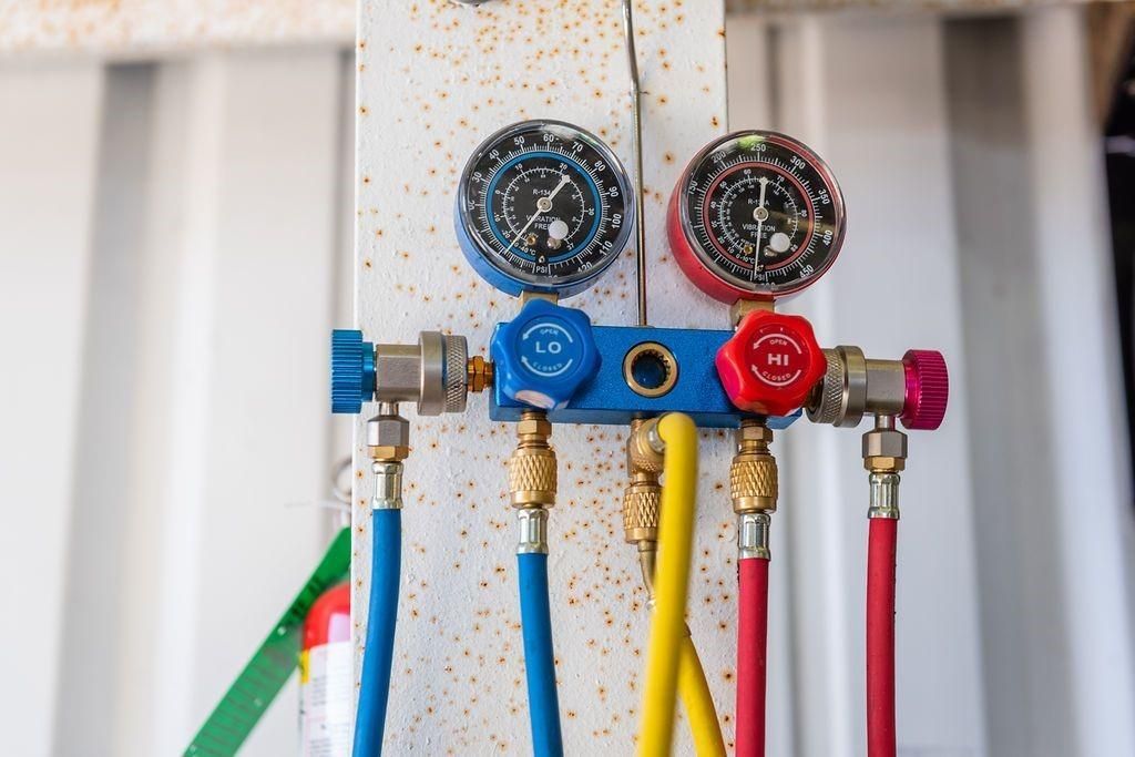 A close up of a bunch of hose and gauges on a pole.