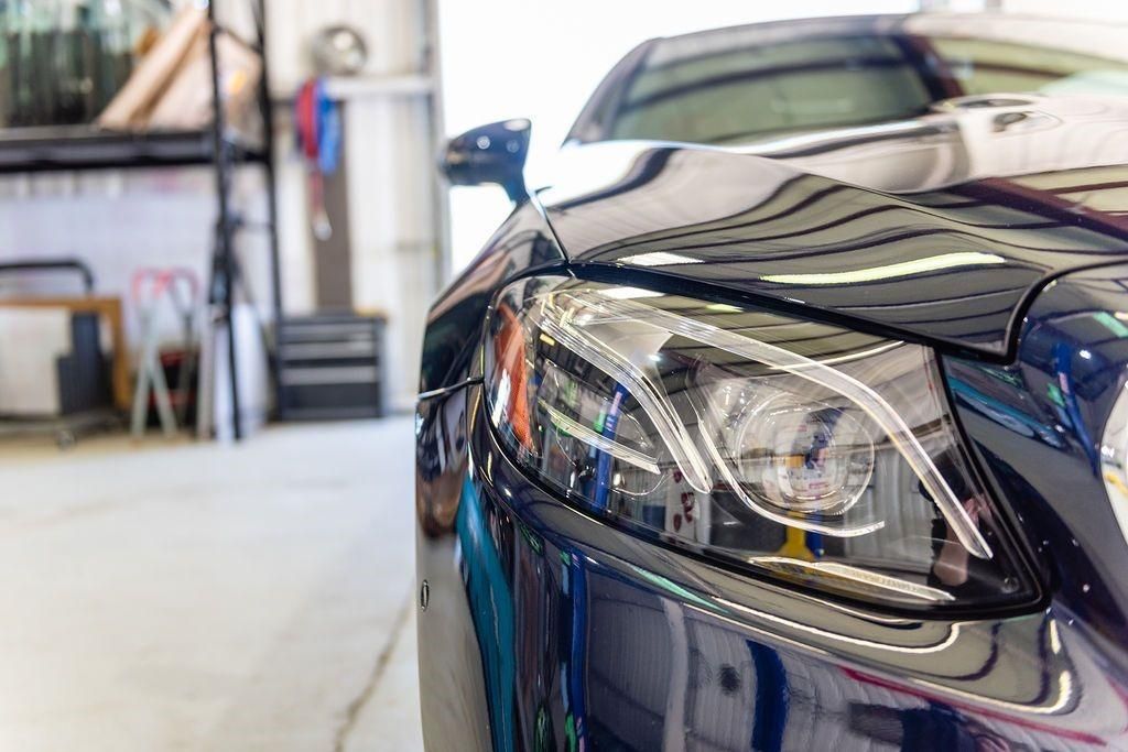 A close up of a car 's headlight in a garage.