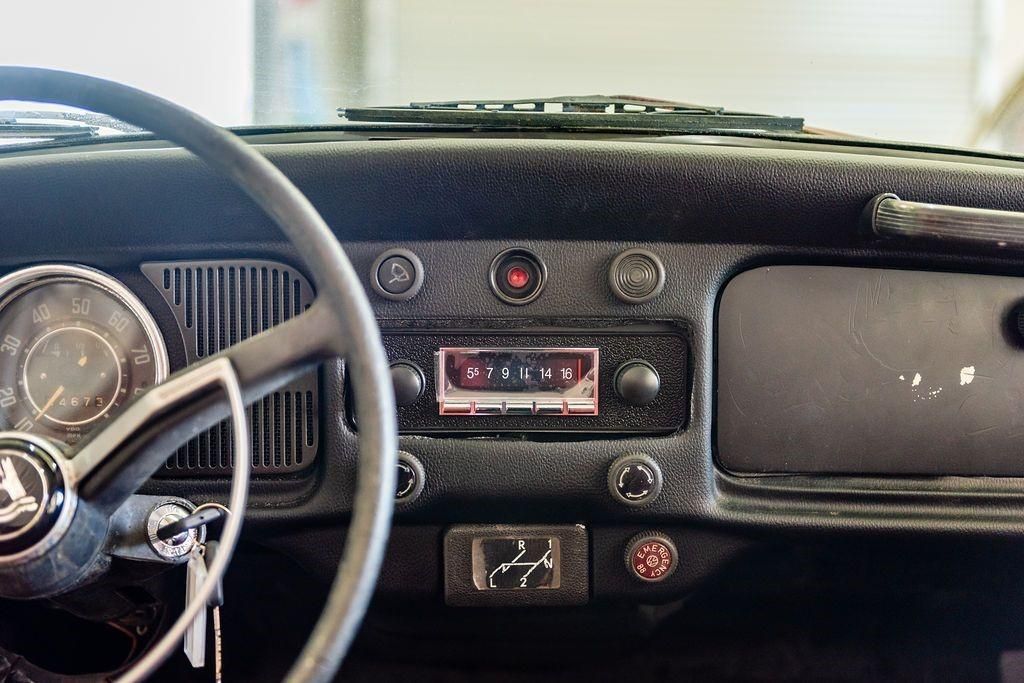 A close up of a car dashboard with a radio and steering wheel