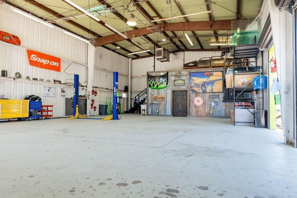 A large empty garage with a sign that says snap on.