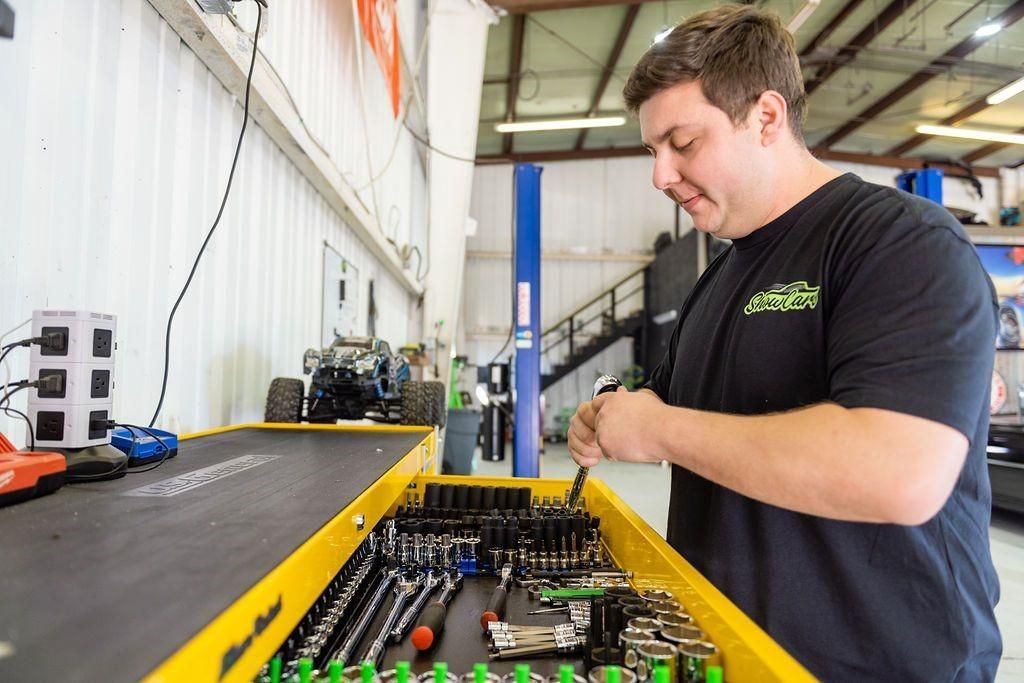 A man is working on a toolbox in a garage.