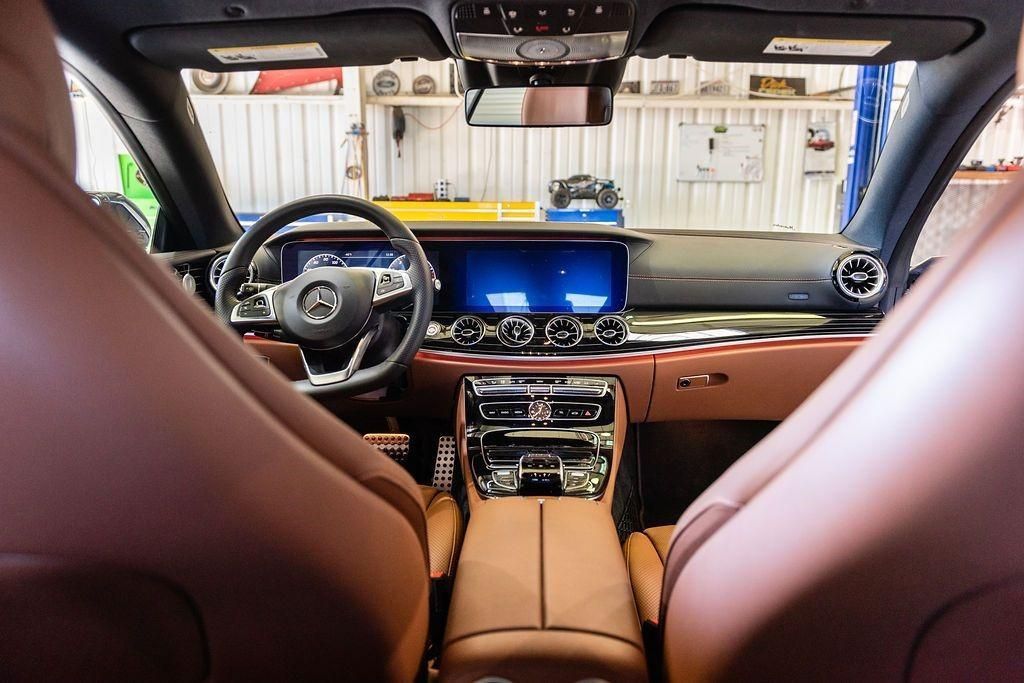 The interior of a car with brown leather seats and a steering wheel.