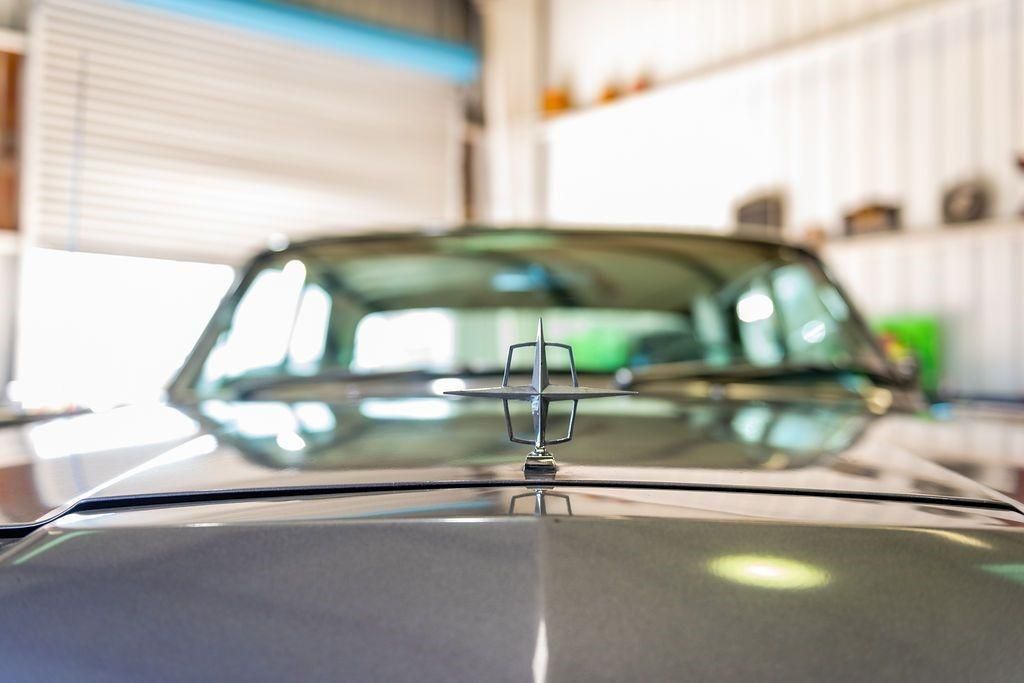 A close up of the hood of a car in a garage.