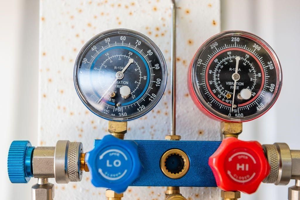 A close up of two gauges with blue and red handles