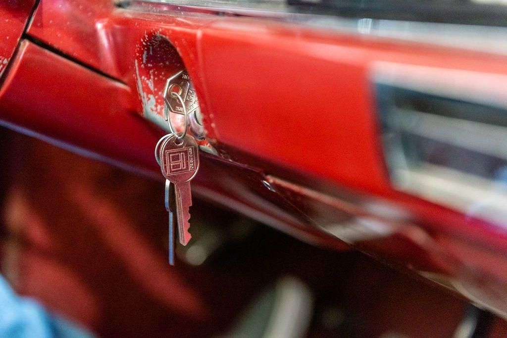 A close up of a red car with a key in it.