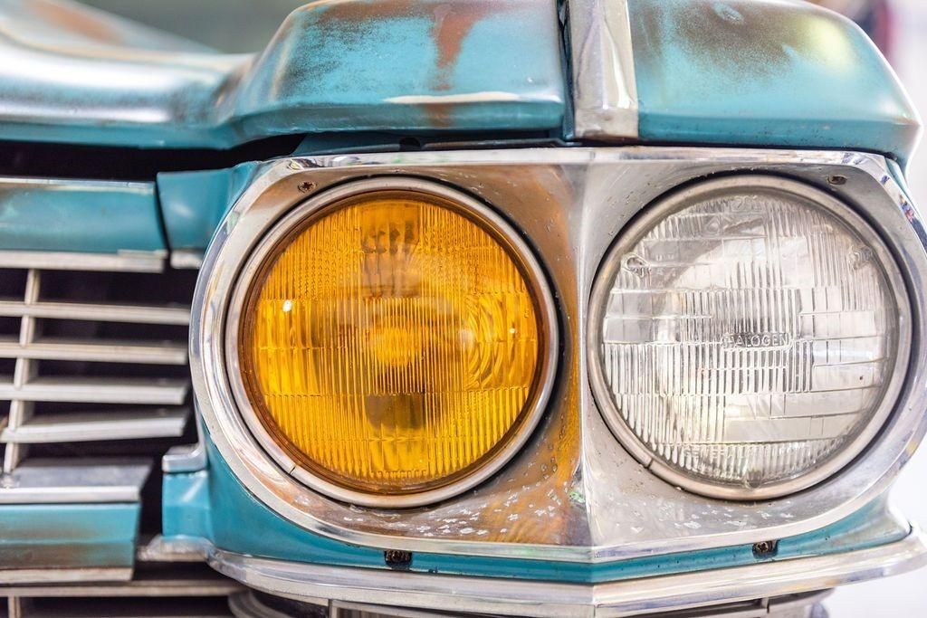 A close up of a blue car with yellow headlights.
