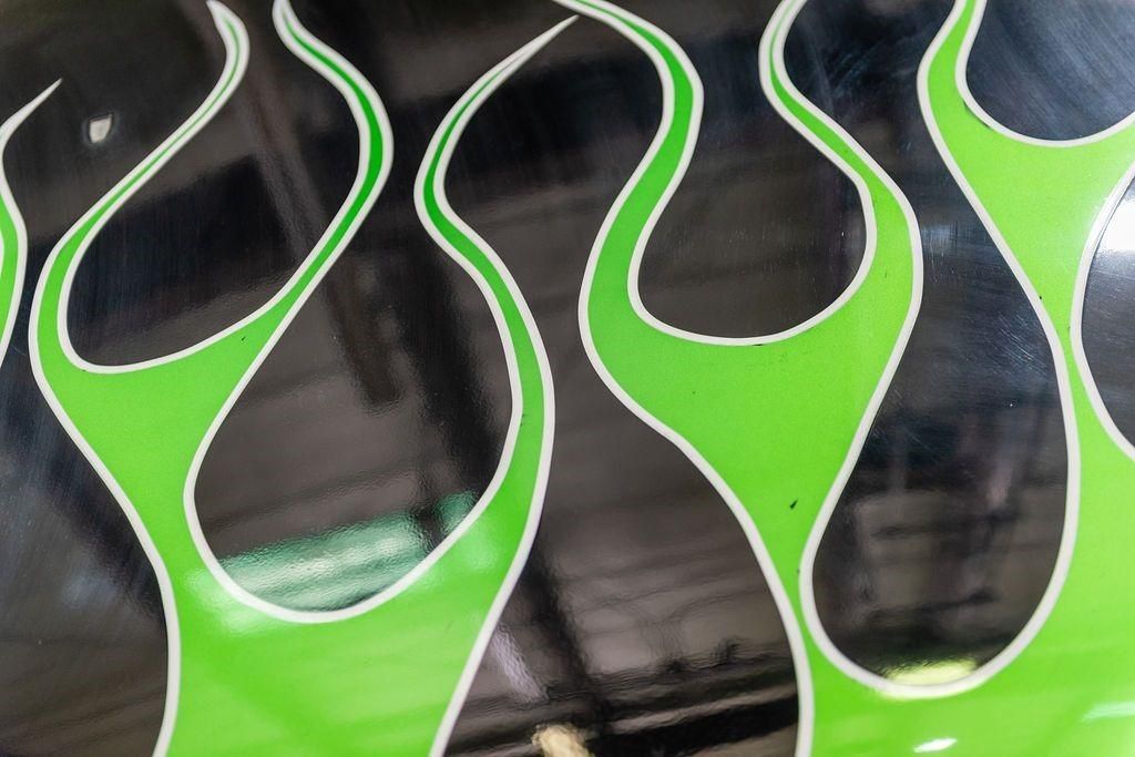 A close up of green flames on a black surface.