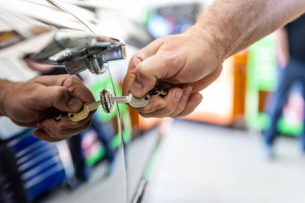 A man is holding a car key in his hand.