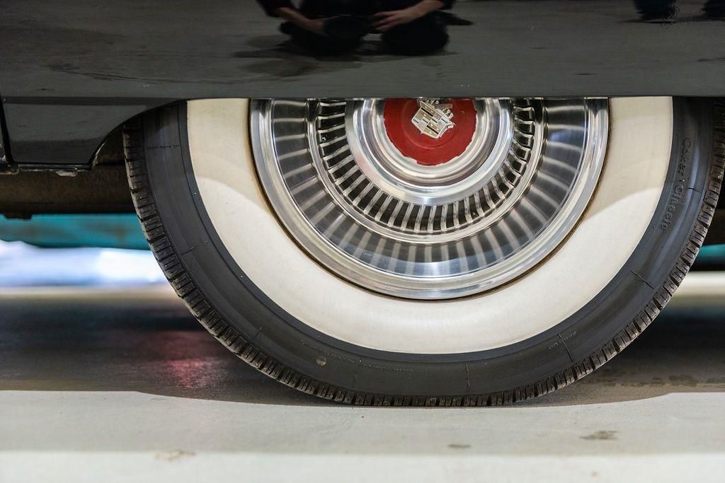 A close up of a car wheel with white tires