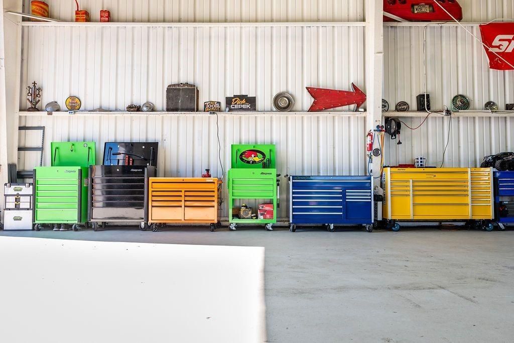 A row of colorful tool boxes are lined up in a garage.