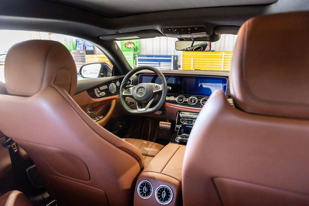 The interior of a car with brown leather seats and a steering wheel.