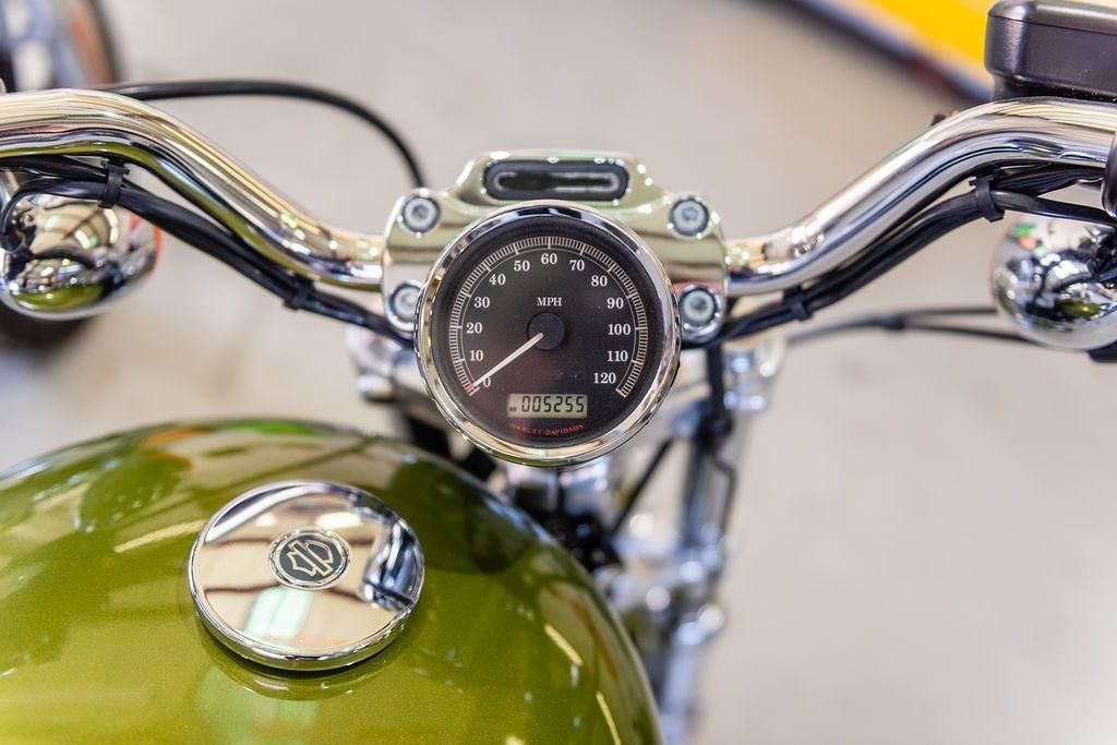 A close up of a green motorcycle with a speedometer.