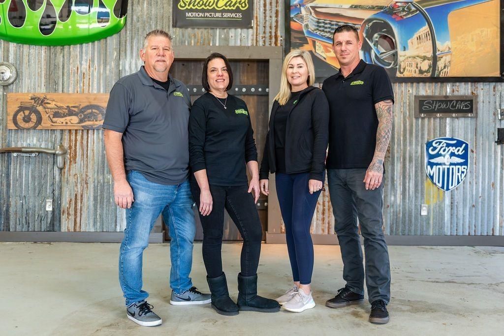 A group of people are posing for a picture in a garage.