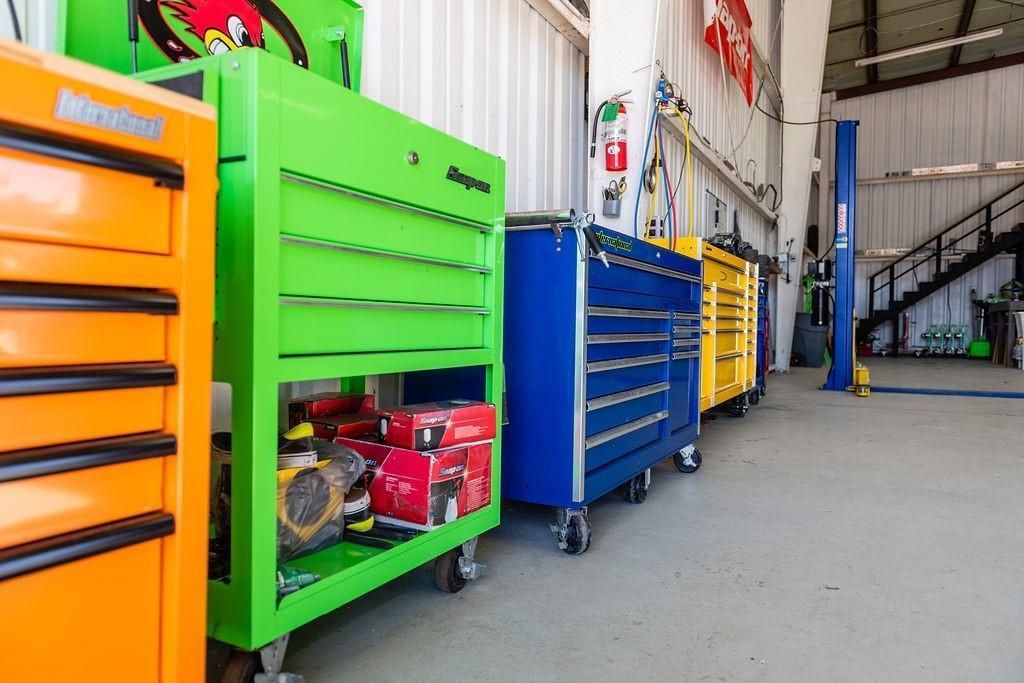 A row of colorful tool boxes are lined up in a garage.