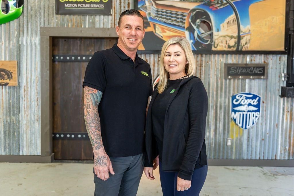 A man and a woman are standing next to each other in a garage.