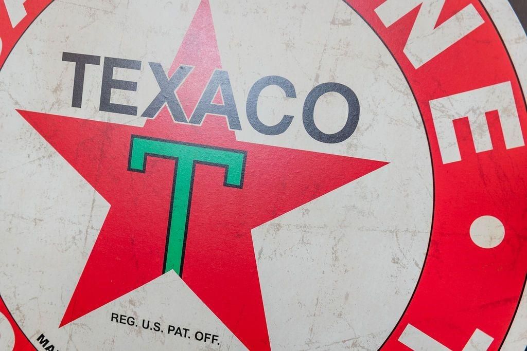 A close up of a texaco sign with a red star