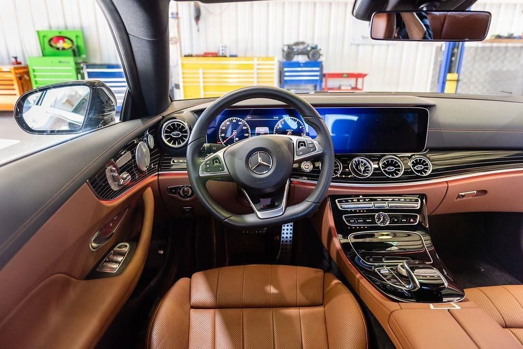 The interior of a car with brown leather seats and a steering wheel.