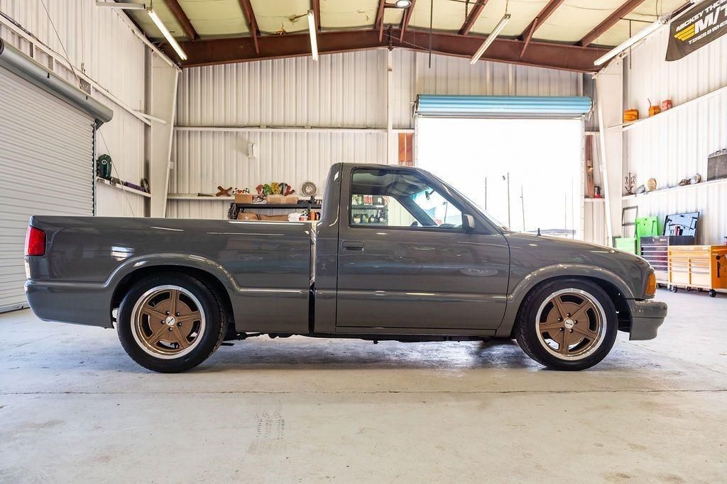 A gray pickup truck is parked in a garage.