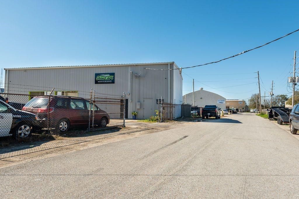 A row of cars are parked in front of a building.