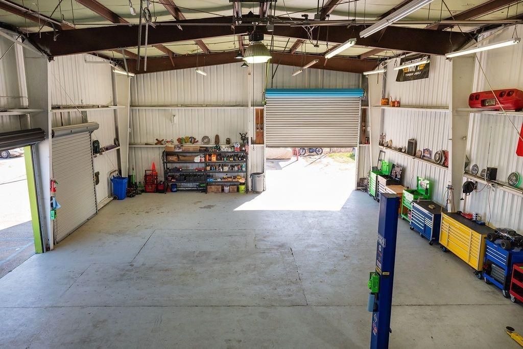 A large empty garage with a lot of tools on the shelves.