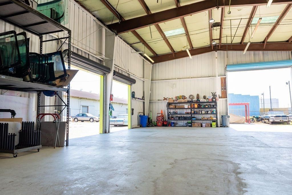 A large empty warehouse with a lot of cars parked inside of it.
