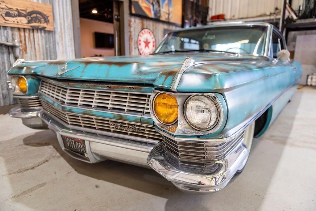A blue cadillac is parked in a garage.