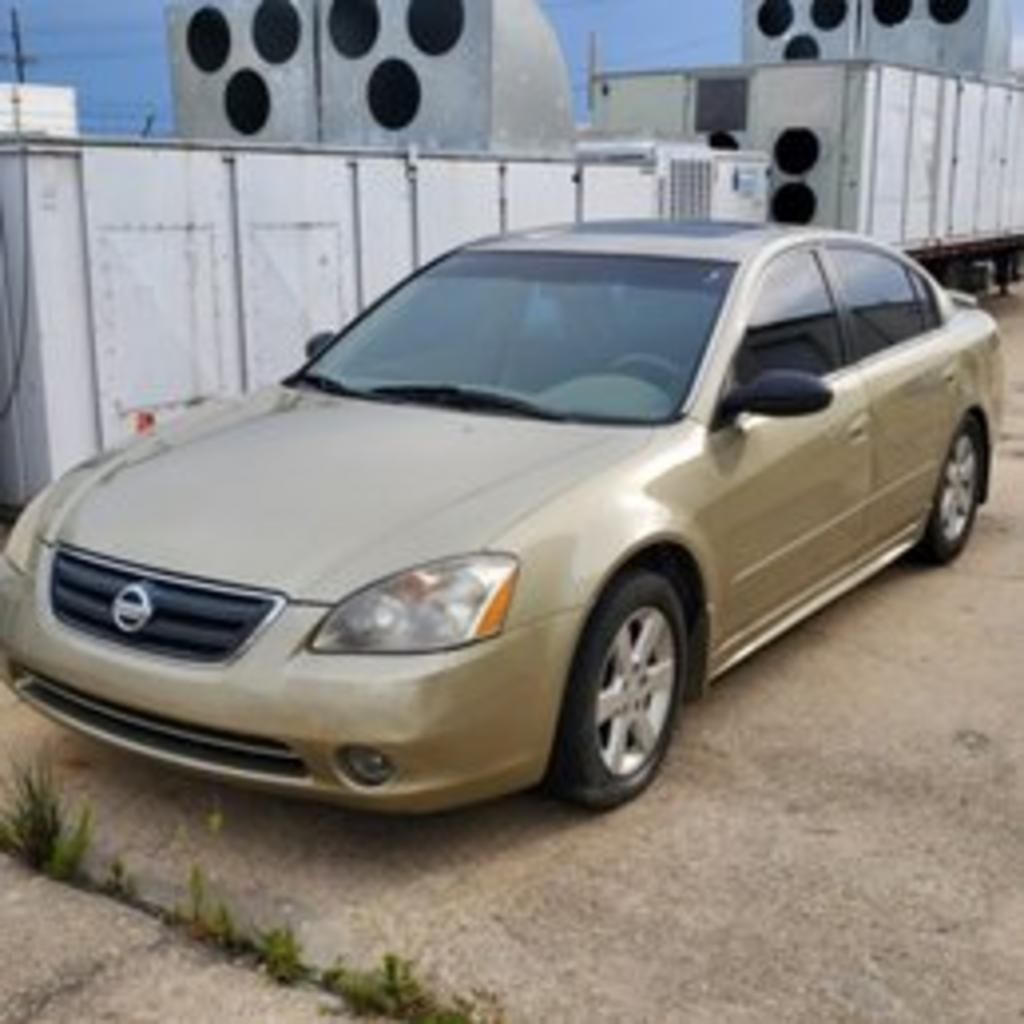 A nissan altima is parked in a parking lot
