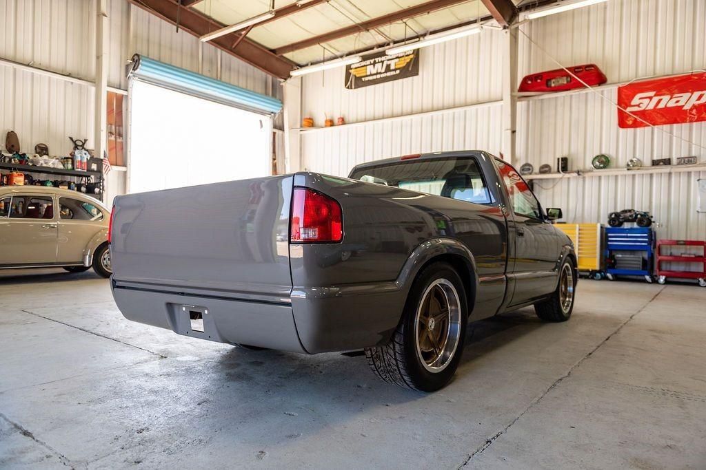 A gray pickup truck is parked in a garage.