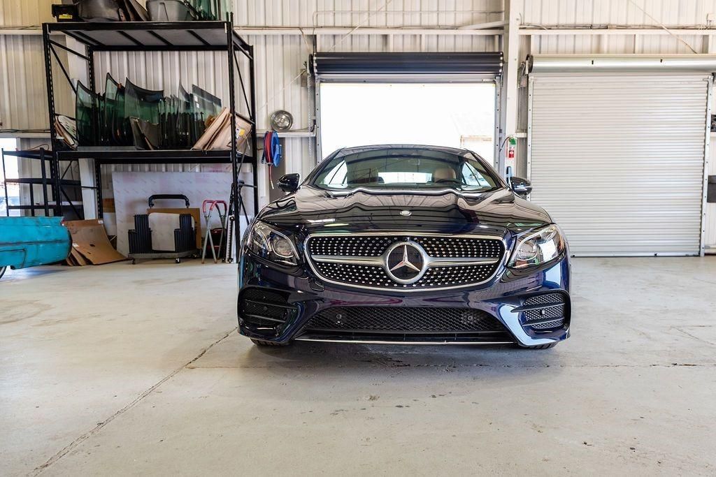 A black mercedes benz is parked in a garage.