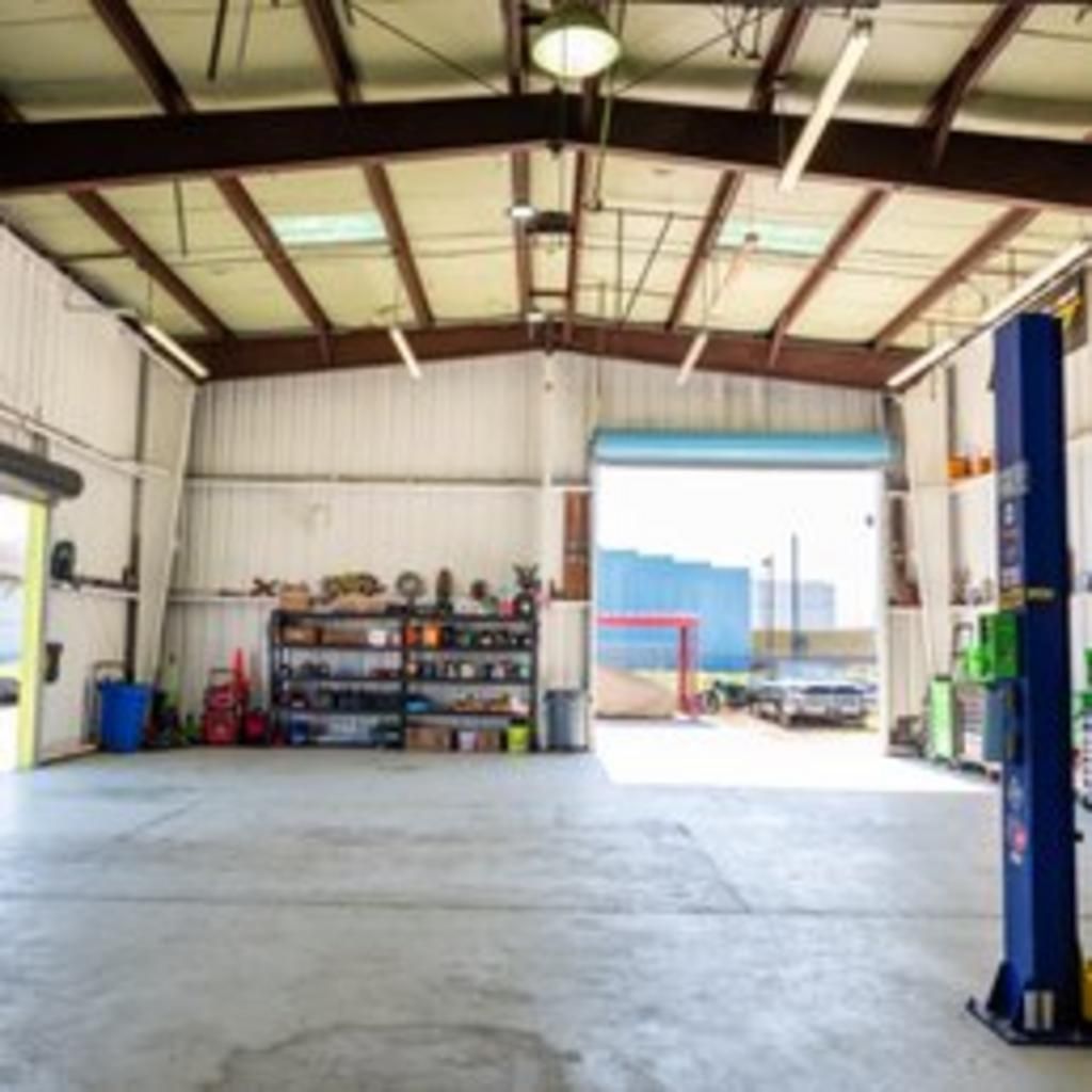 An empty garage with a blue lift in the middle