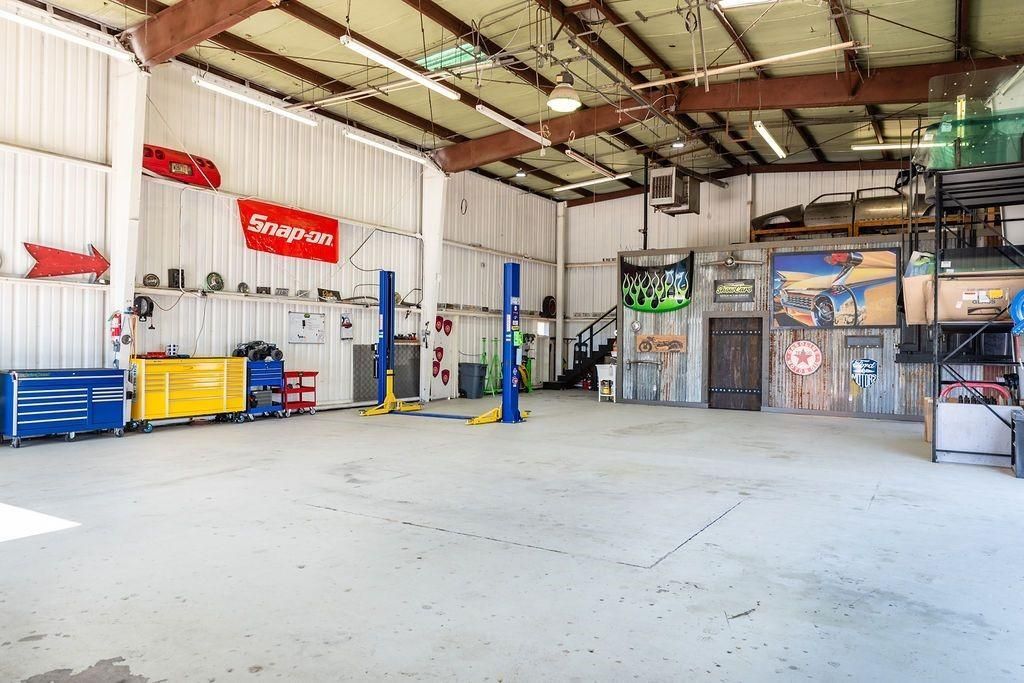 A large empty garage with a snap on sign on the wall.