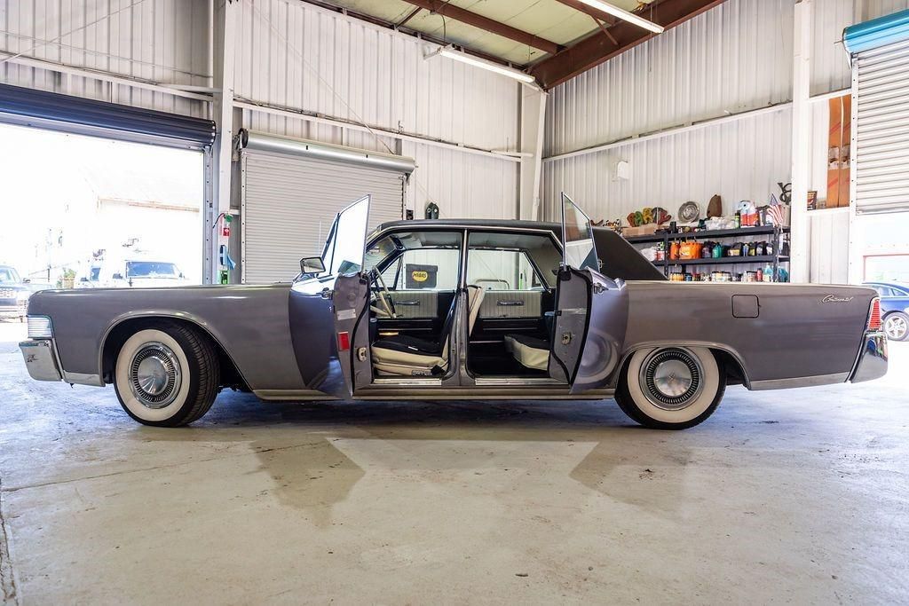 A car is parked in a garage with its doors open