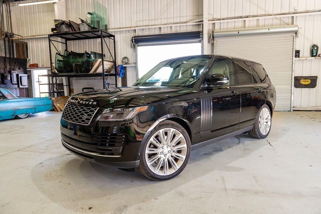 A black range rover is parked in a garage.
