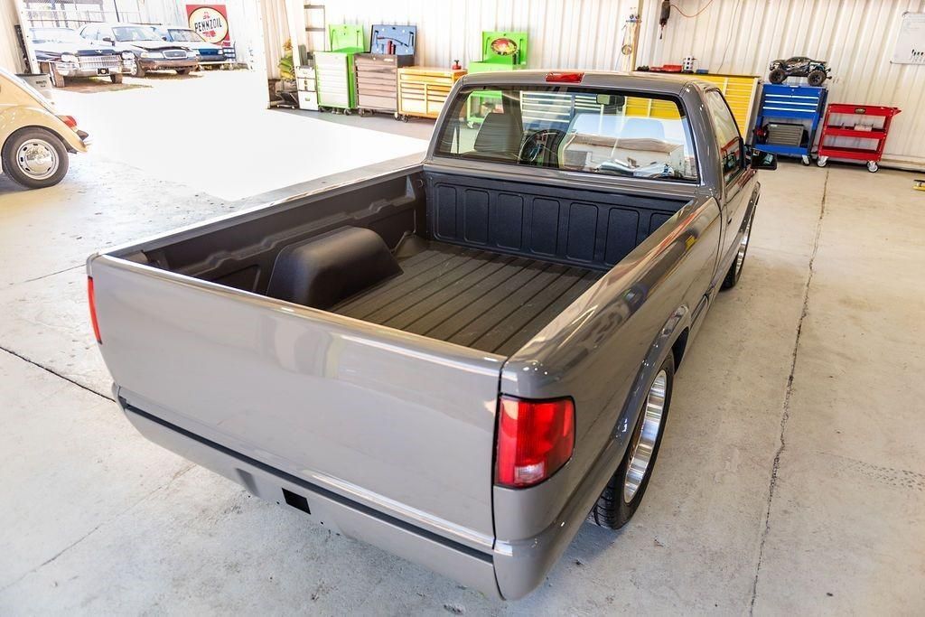 A pickup truck is parked in a garage with the bed empty