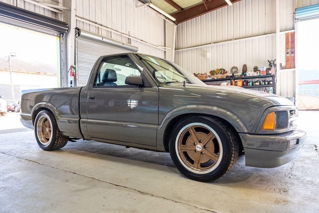 A gray pickup truck is parked in a garage.