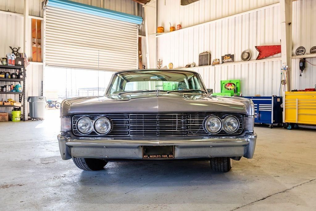 A car is parked in a garage with a garage door open.