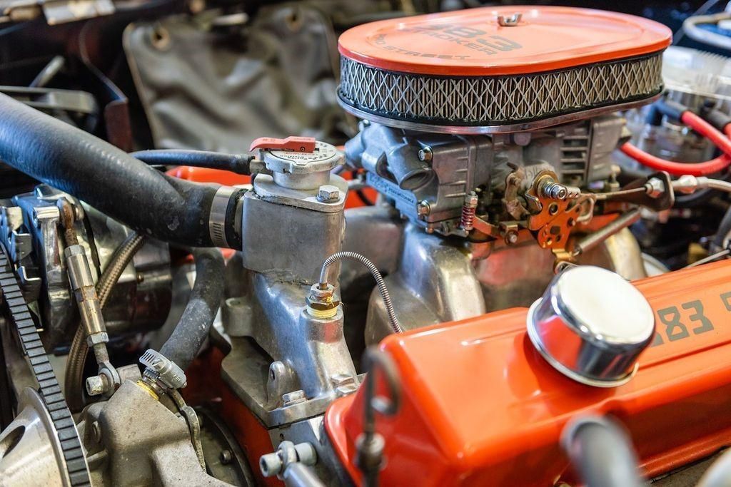 A close up of a car engine with a red air filter