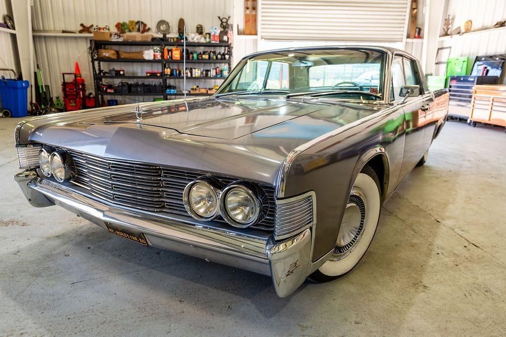 A classic car is parked in a garage with white tires.