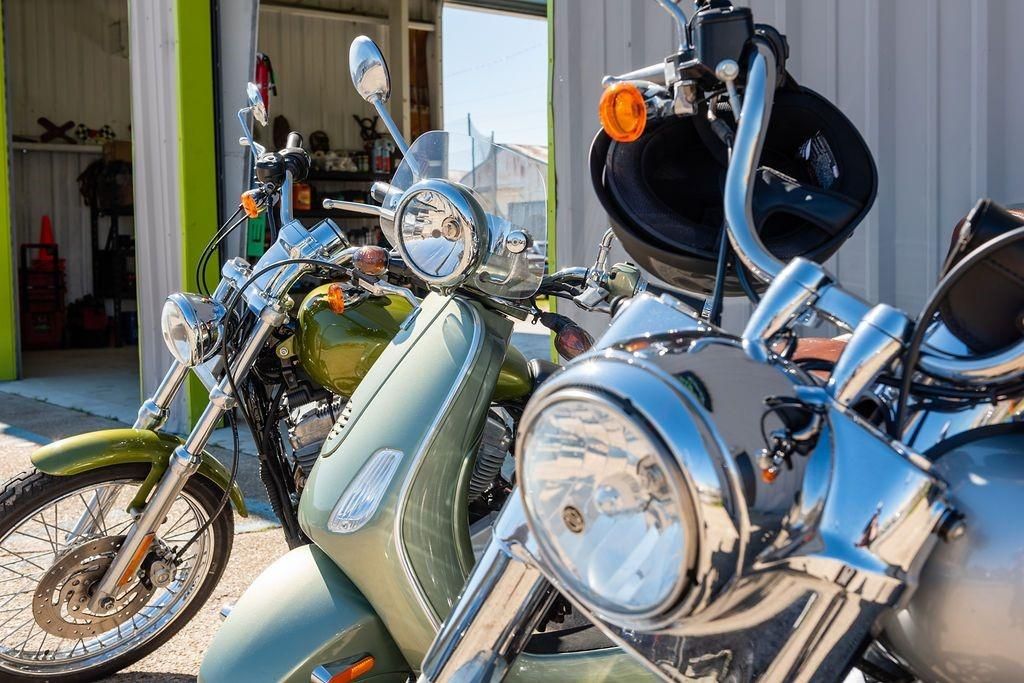 A row of motorcycles are parked in front of a garage.