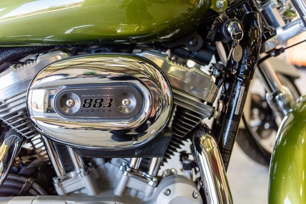 A close up of the engine of a green motorcycle.