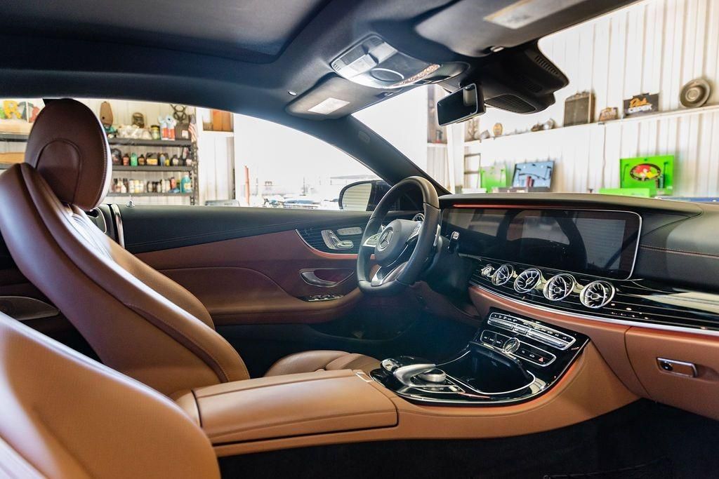 The interior of a car with brown leather seats and a steering wheel.