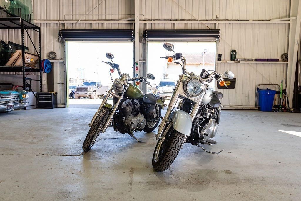 Two motorcycles are parked next to each other in a garage.