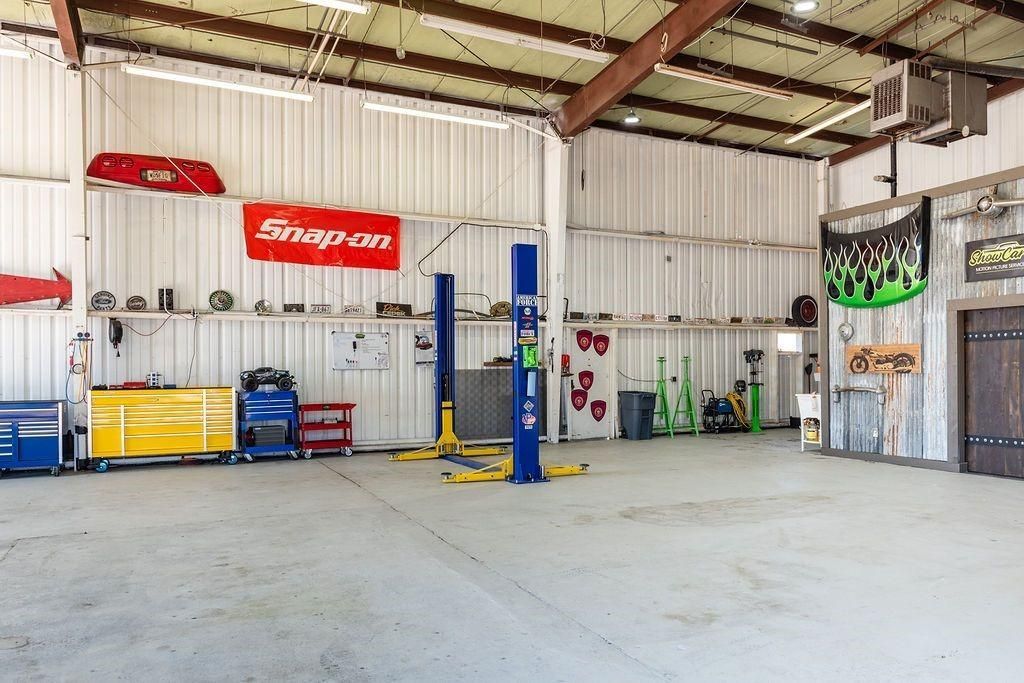 A large empty garage with a snap on sign on the wall.