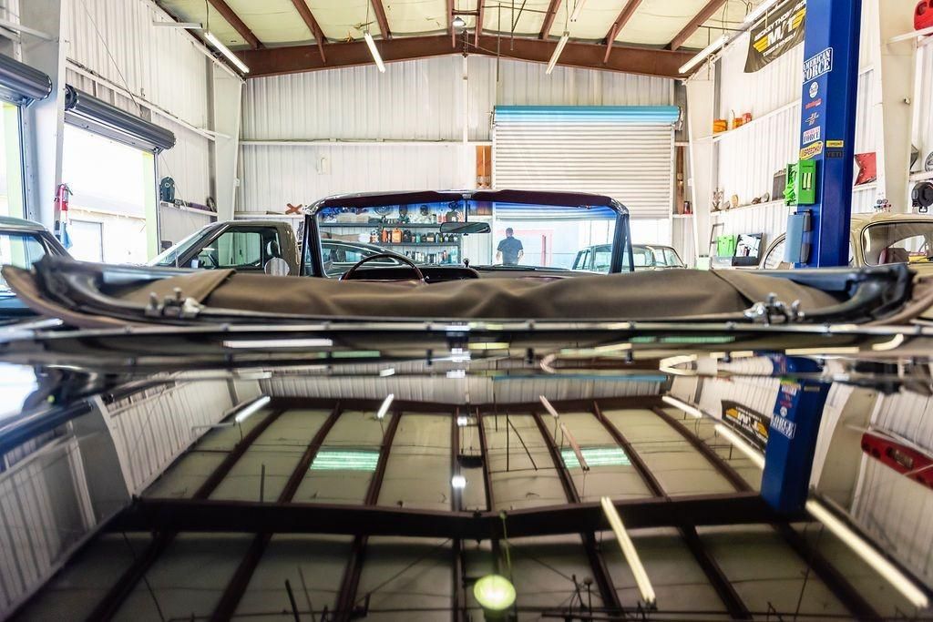 A car is sitting on a lift in a garage.