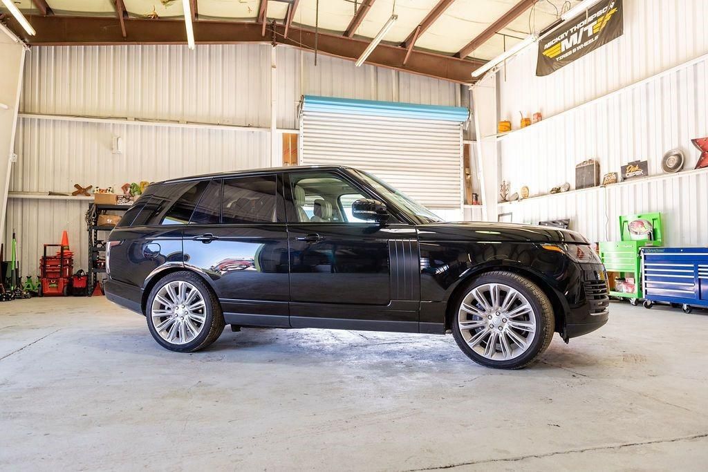 A black range rover is parked in a garage.