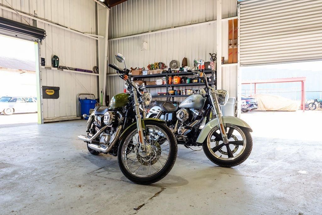 Two motorcycles are parked in a garage next to each other.