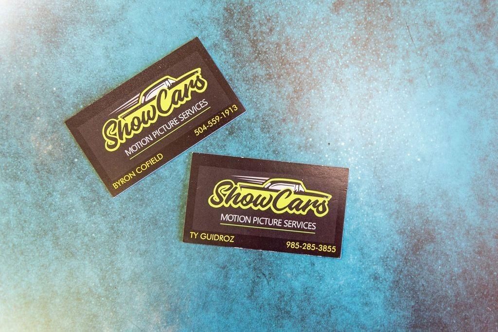 Two show cars business cards on a blue surface