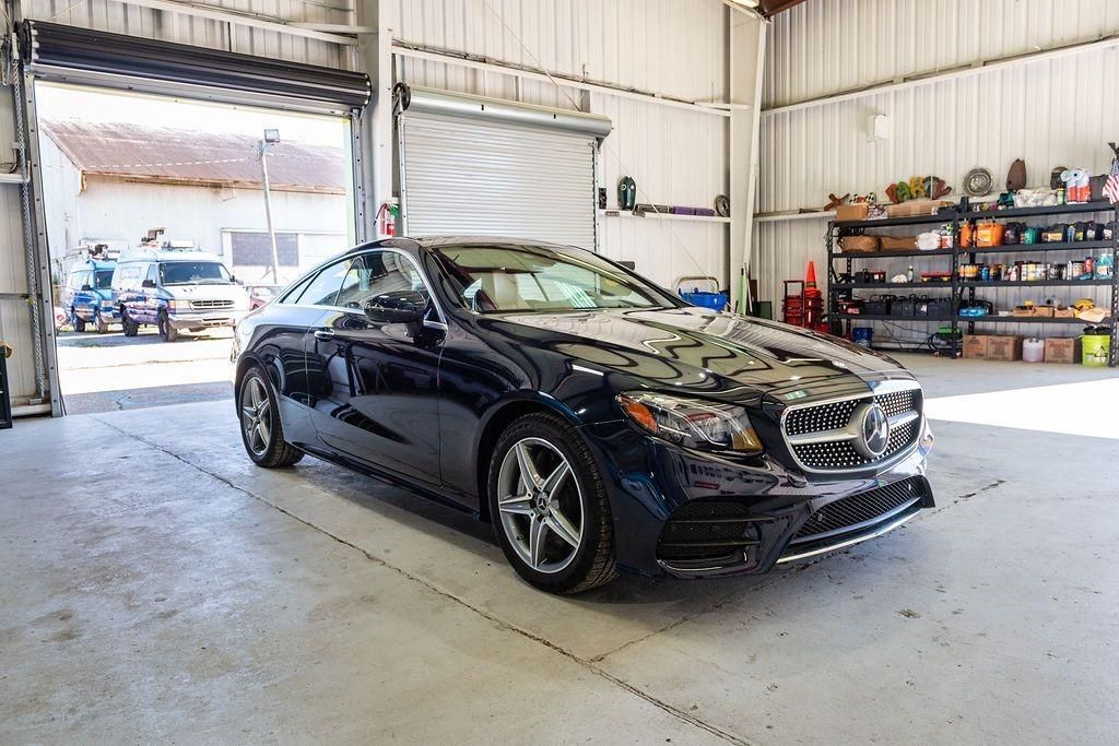A black sports car is parked in a garage.