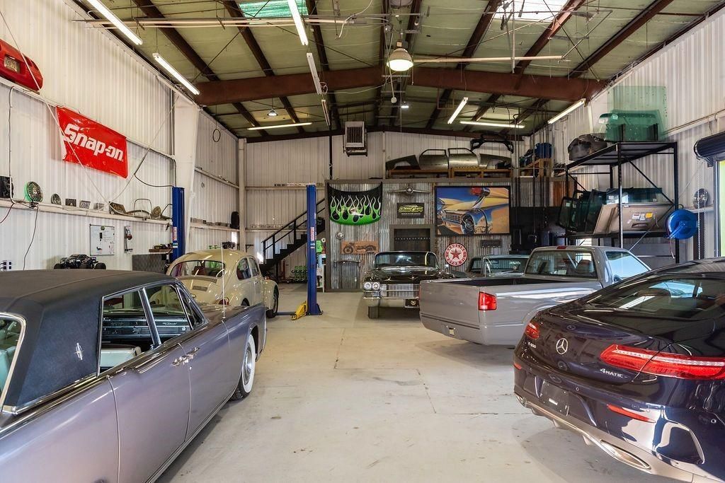 A row of cars are parked inside of a garage.